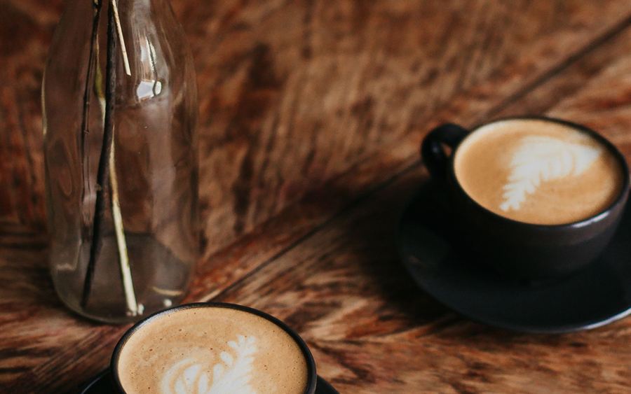 Two cups of coffee on a wooden table